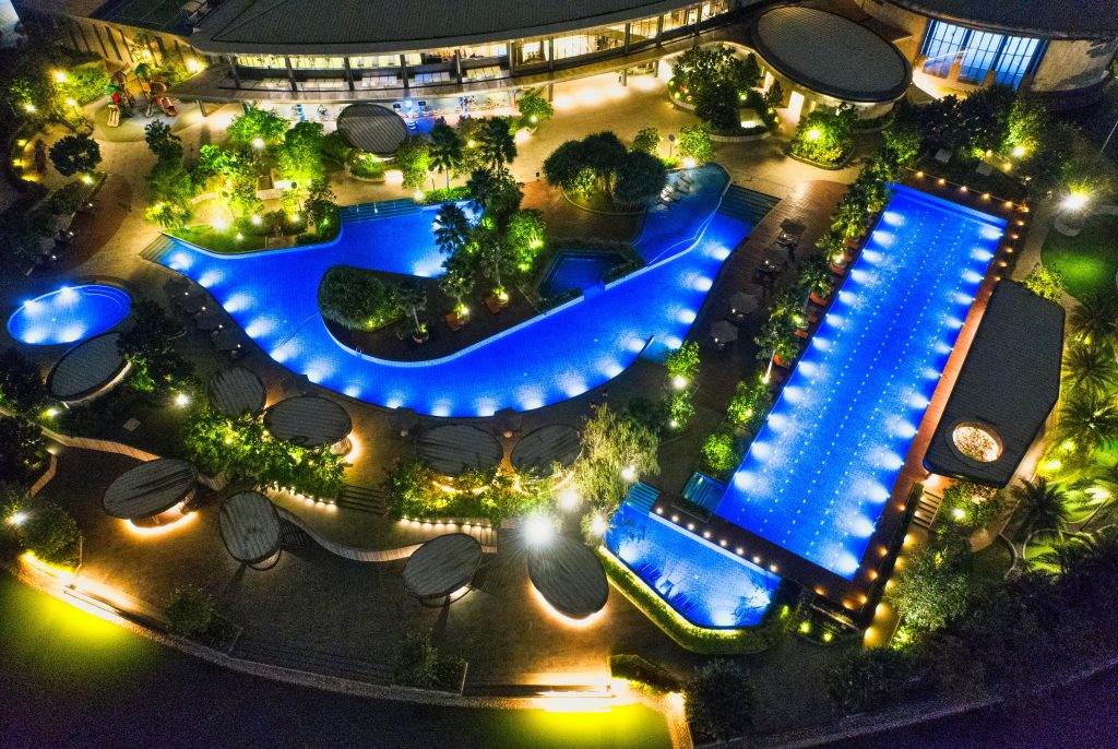 Stunning aerial night view of an illuminated resort pool in Banten, Indonesia.